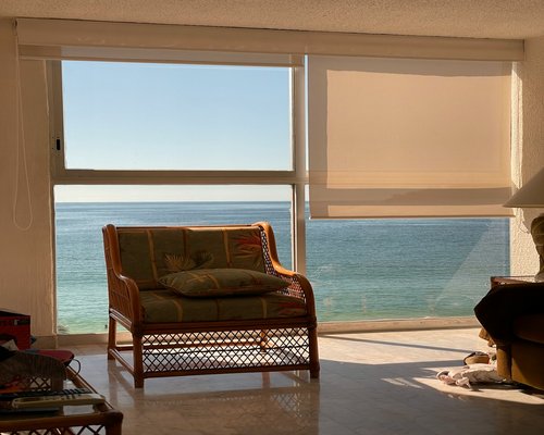A bright, sunlit living room in Mexico with soft curtains diffusing the intense light