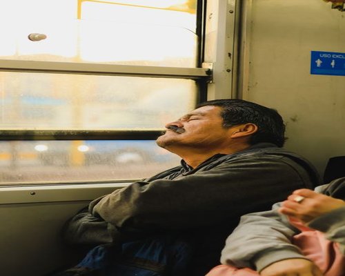 Commuter listening to a podcast on a bus in Mexico, resting their eyes